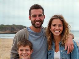 Famille Dubois souriante devant un minivan sur une plage bretonne.