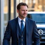 Homme en costume sortant d'un Mercedes GLC devant un immeuble de bureaux